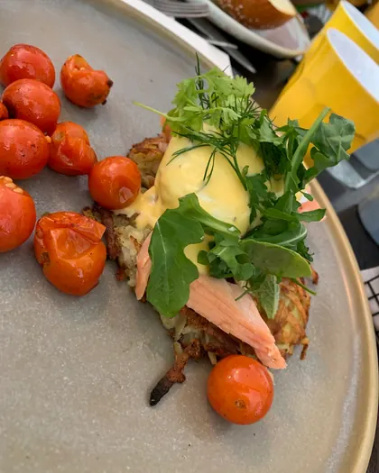 Smoked trout eggs benedict on rosti with roast cherry tomatoes
