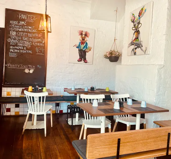 Framed rabbit artwork and the chalkboard menu above timber tables